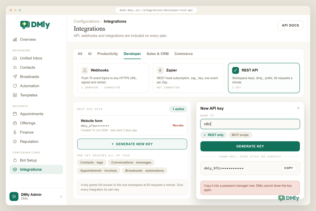 The DMly Integrations screen on the Developer tab showing the Webhooks, Zapier and REST API tiles, a list holding one existing key called Website form, and an open New API key dialog with the name field filled in as n8n, a scope pair below it where REST only is ticked and MCP scope is not, a Generate key button, and the one-time key display reading dmly_9f2c with the rest masked next to a warning that DMly cannot show the key again.